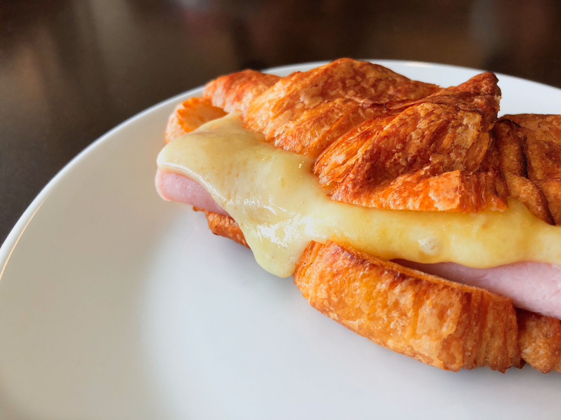 Croissant ham cheese on white dish